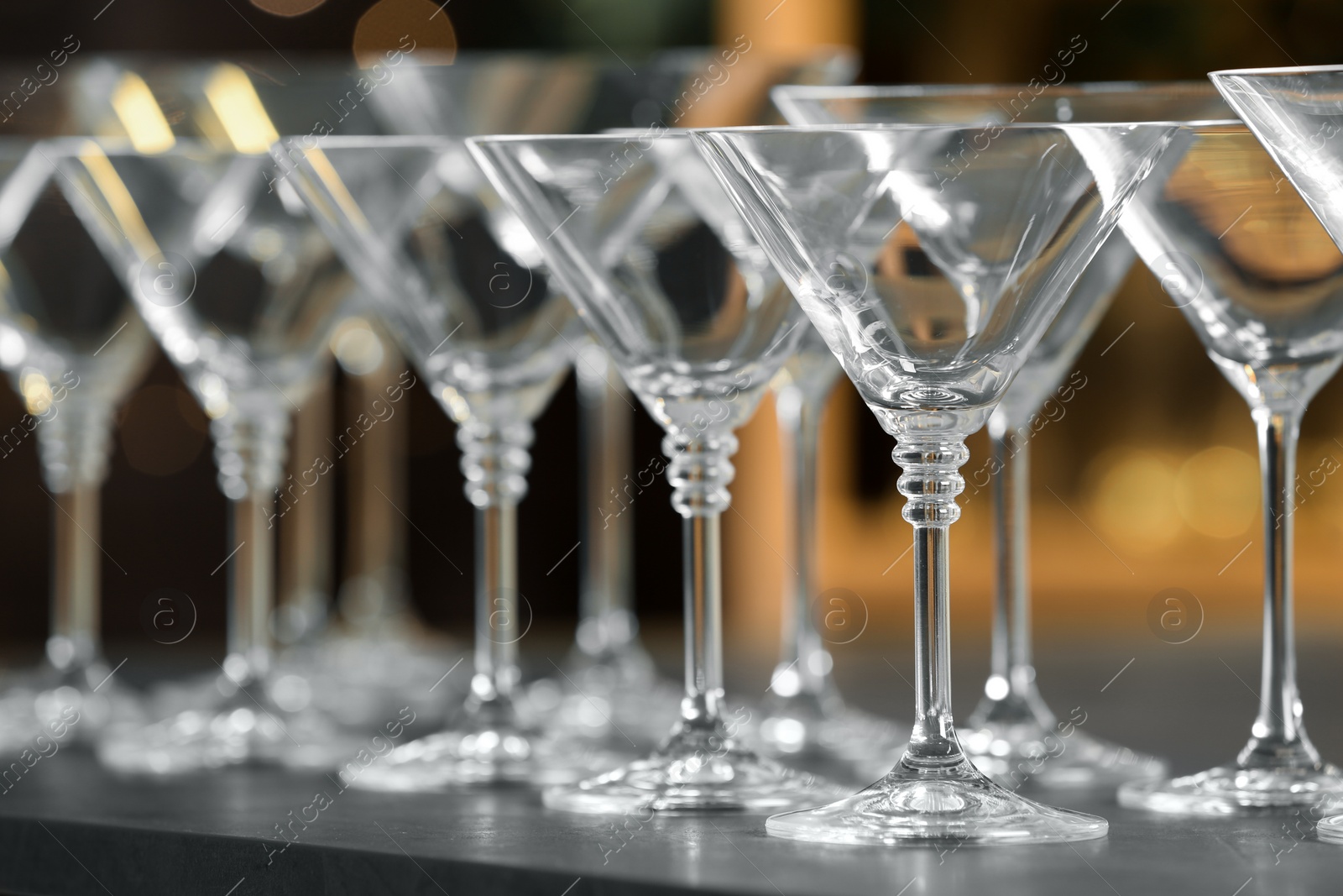 Photo of Empty martini glasses on table against blurred background