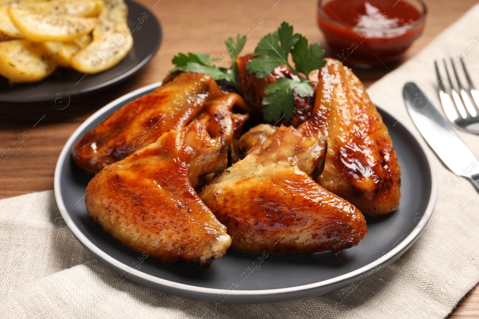 Photo of Delicious fried chicken wings served on wooden table