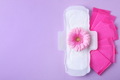 Menstrual pads and flower on color background, flat lay with space for text. Gynecological care