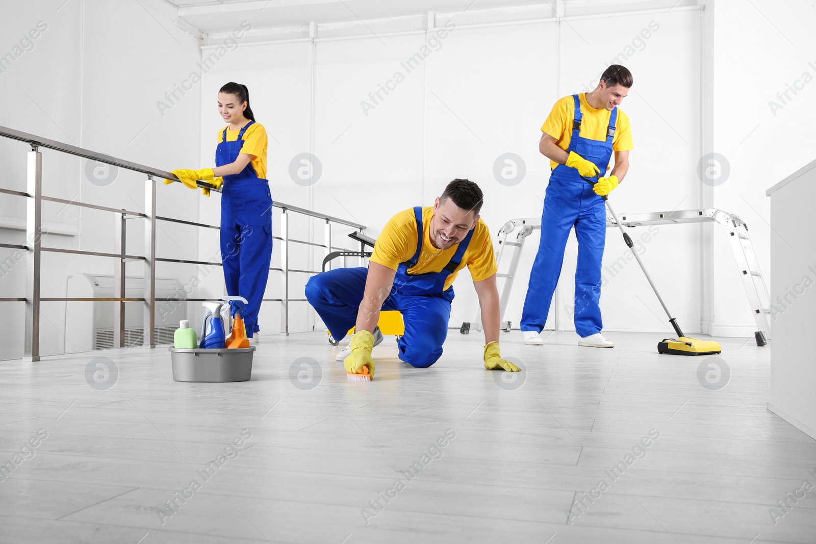 Photo of Team of professional janitors cleaning room after renovation