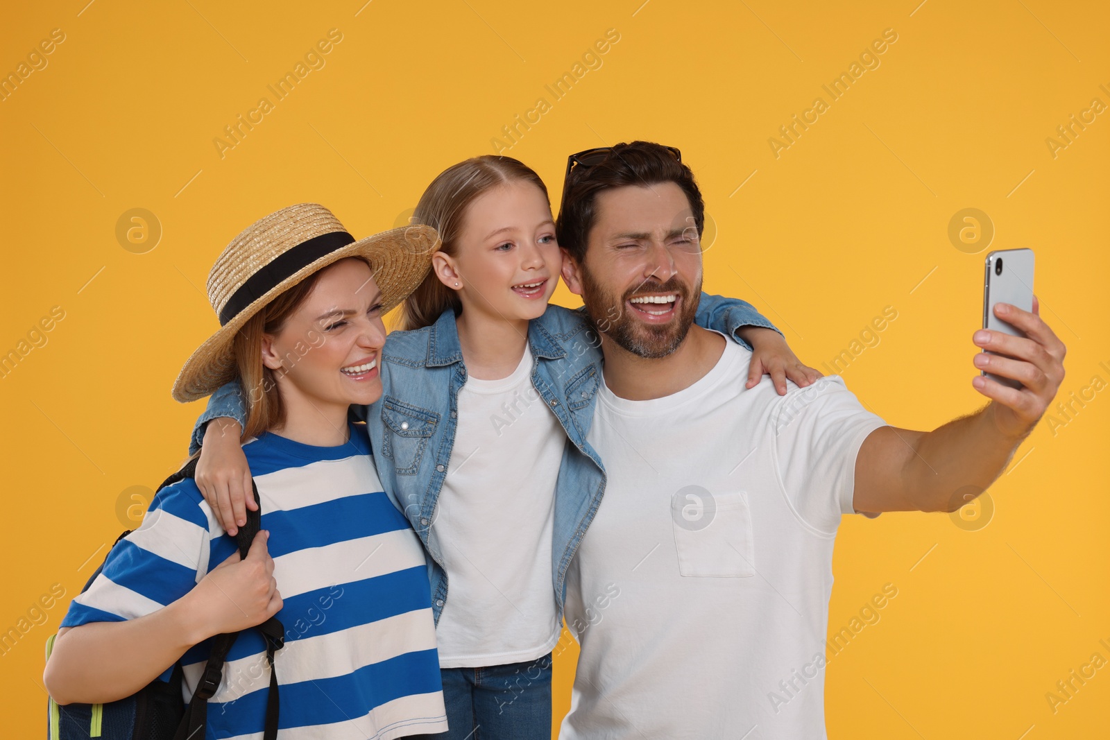 Photo of Happy family taking selfie on orange background