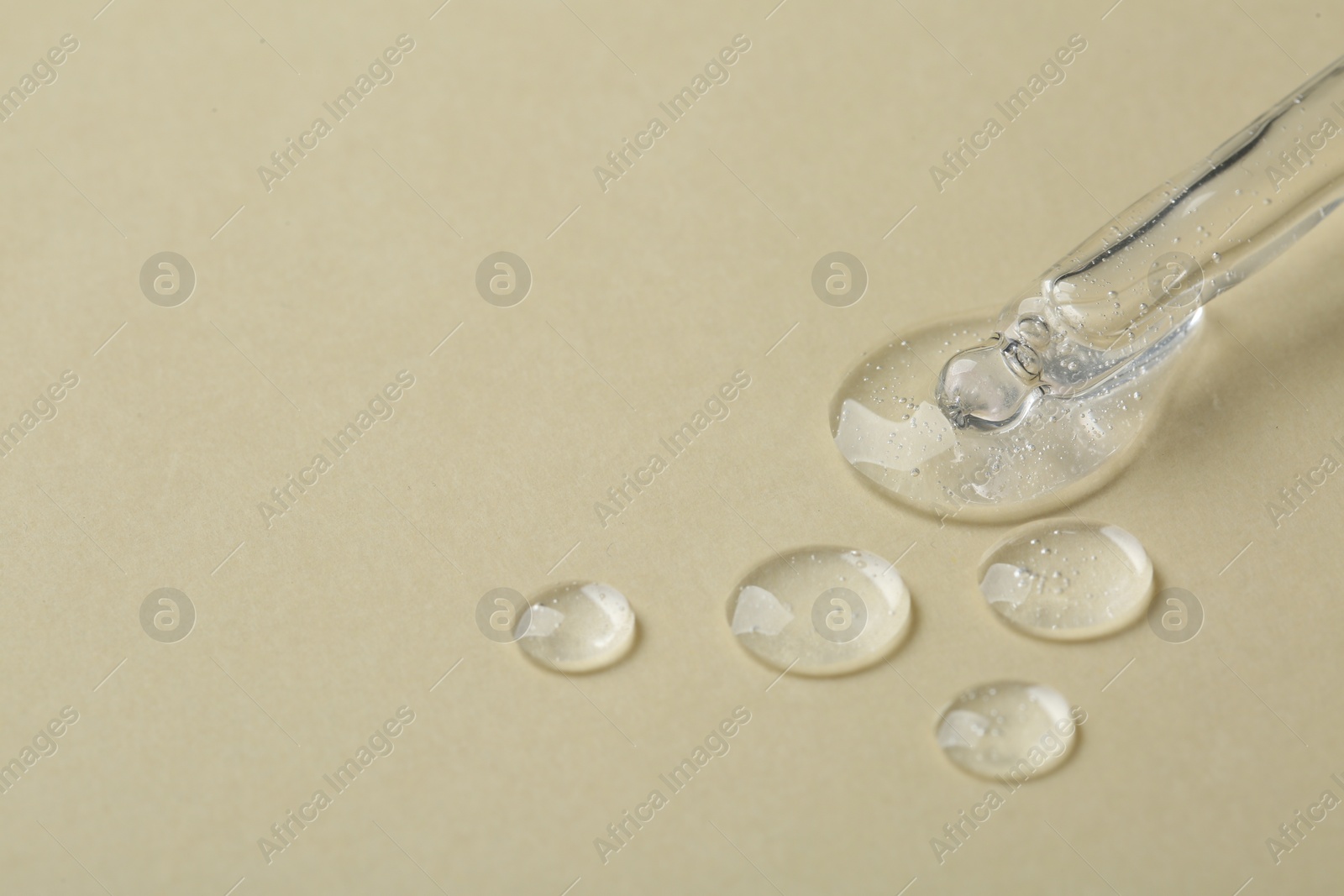 Photo of Pipette with samples of cosmetic serum on beige background. Space for text