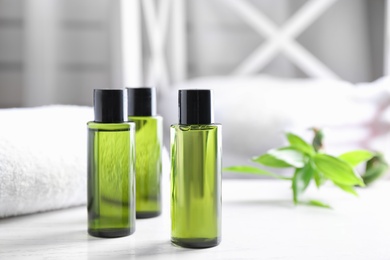 Photo of Mini bottles with cosmetic products on white table indoors