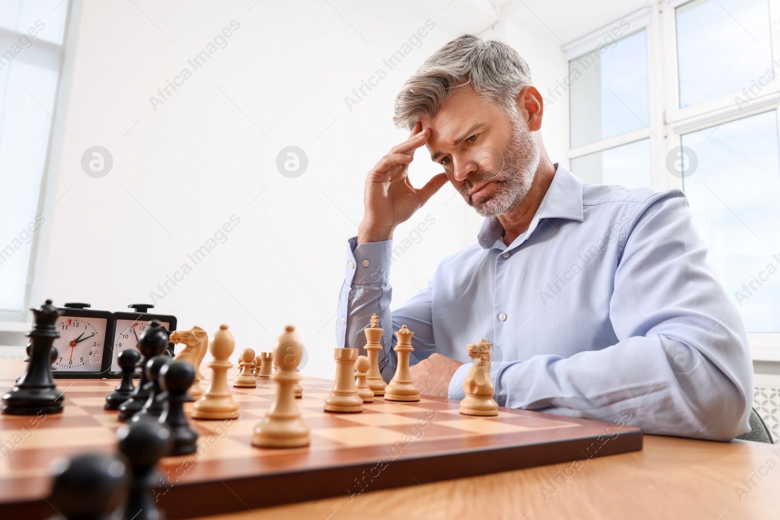 Photo of Man playing chess during tournament at table indoors