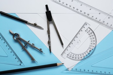 Photo of Flat lay composition with different rulers, pencil and compasses on light blue background