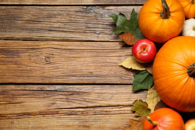 Thanksgiving day. Flat lay composition with pumpkins on wooden table, space for text