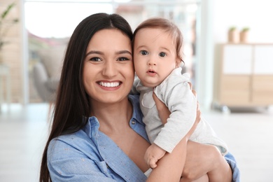 Photo of Portrait of young mother and her adorable baby at home