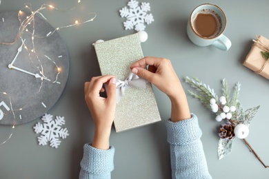 Woman with Christmas gift box at table, top view