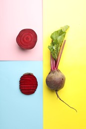 Whole and cut fresh red beets on color background, flat lay