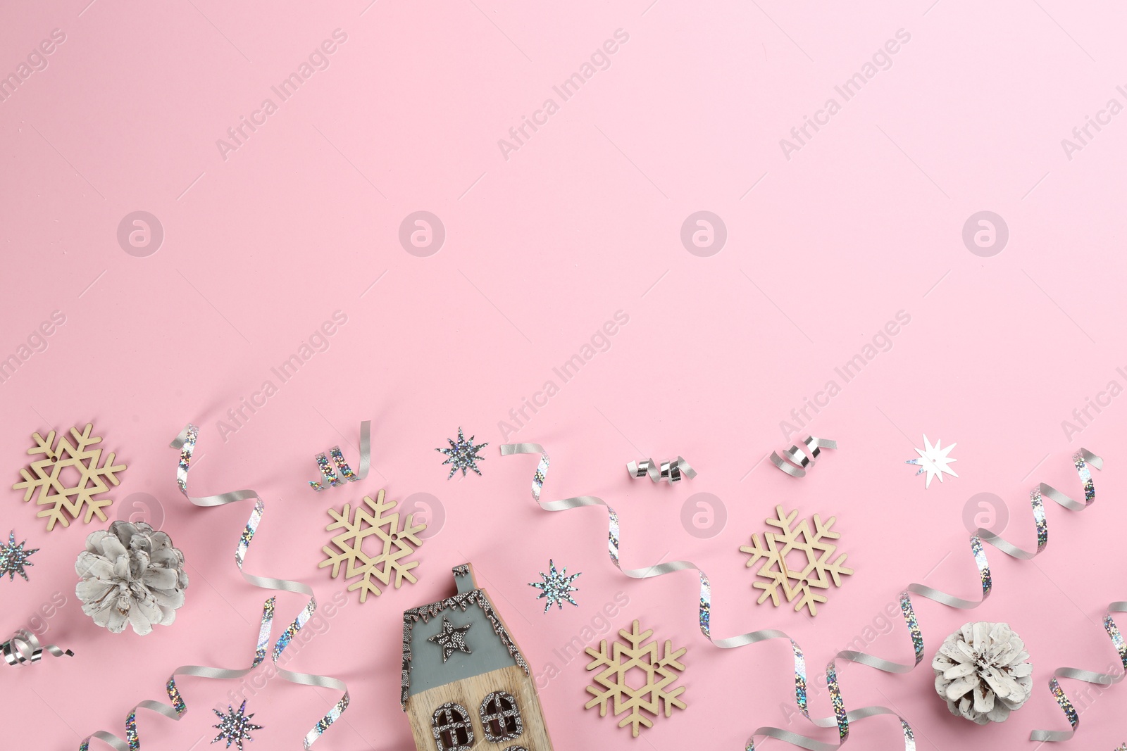 Photo of Flat lay composition with serpentine streamers and Christmas decor on pink background. Space for text