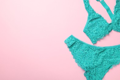 Photo of Turquoise women's underwear on pink background, flat lay. Space for text