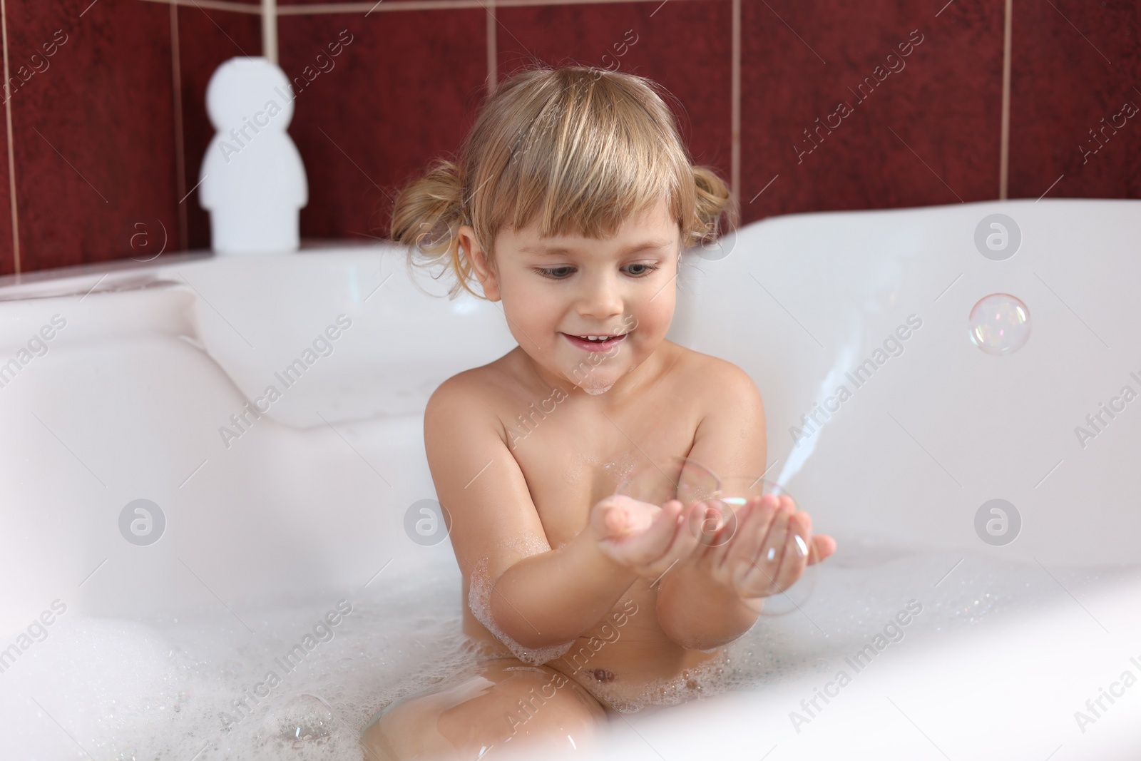 Photo of Happy girl having fun in bathtub at home