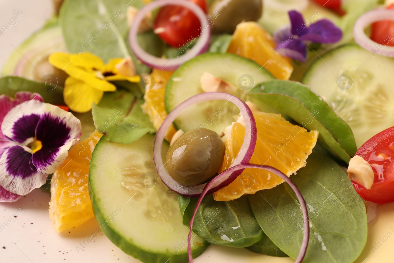 Photo of Delicious salad with orange, spinach, olive and vegetables on plate, closeup