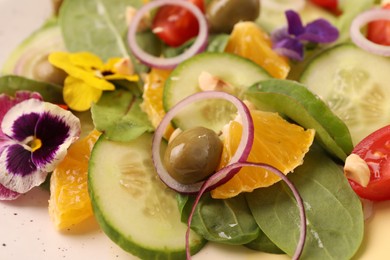 Photo of Delicious salad with orange, spinach, olive and vegetables on plate, closeup