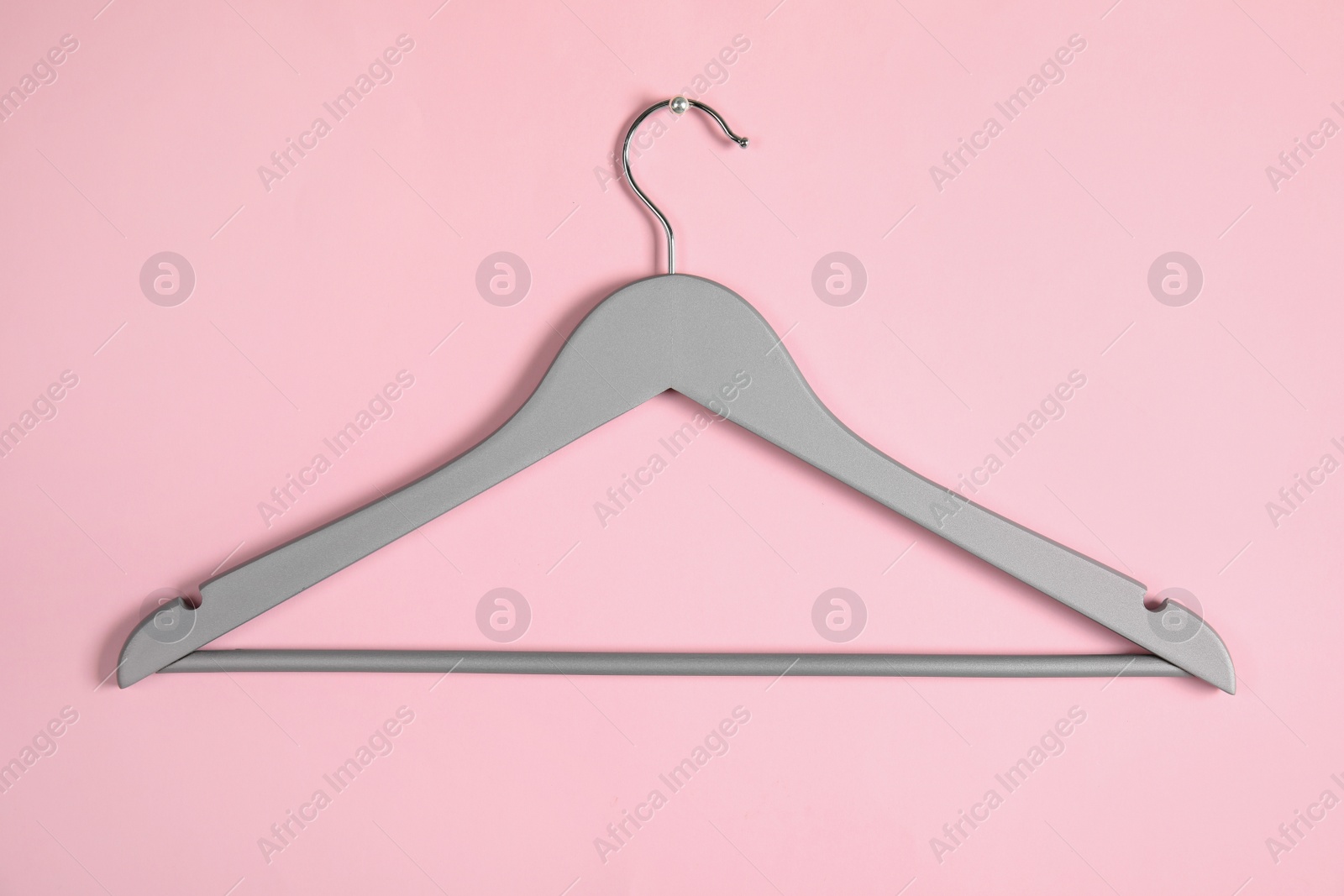 Photo of Empty clothes hanger on color background. Wardrobe accessory