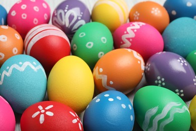 Photo of Many bright Easter eggs as background, closeup view