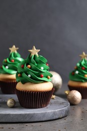 Photo of Christmas tree shaped cupcakes on grey table