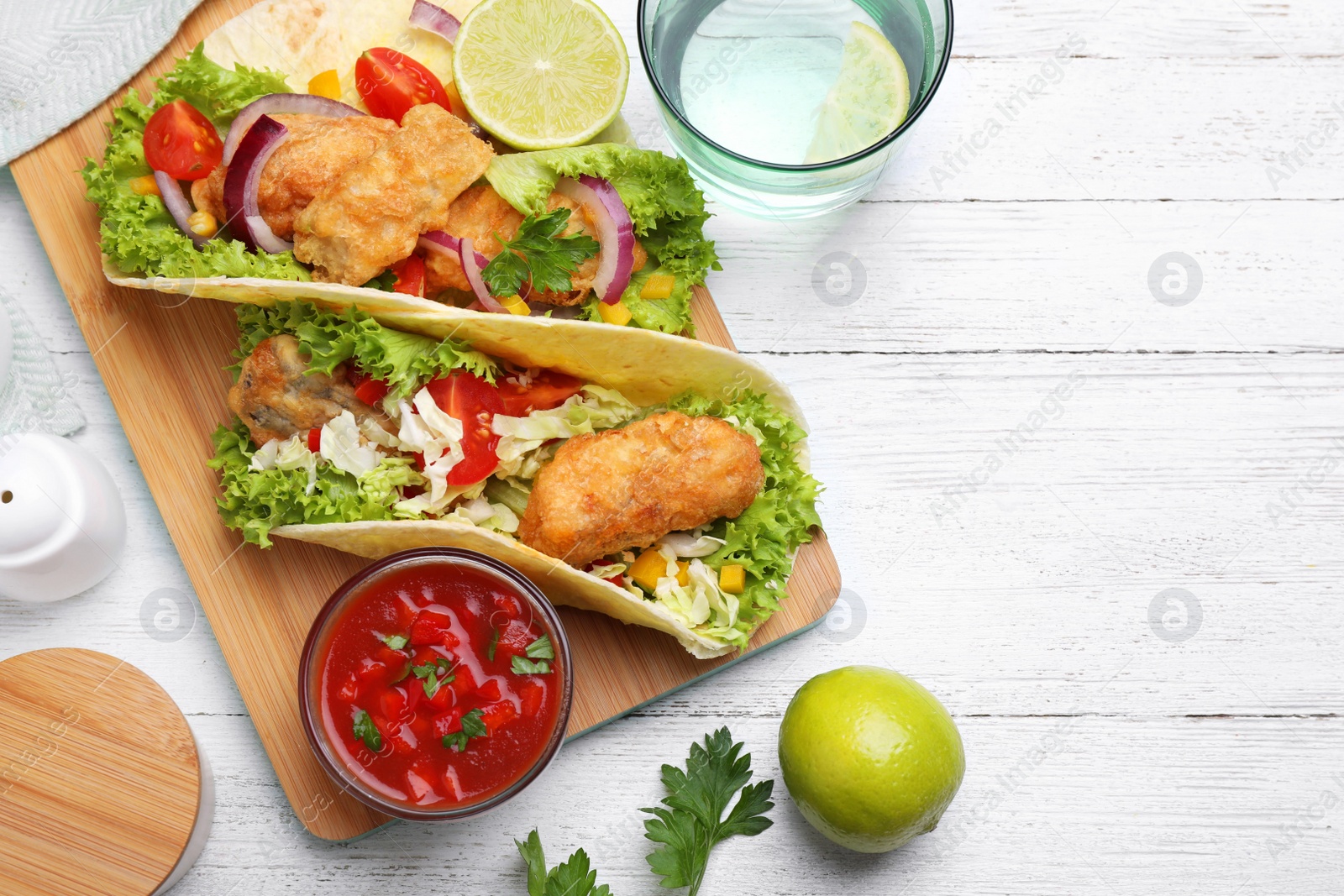 Photo of Delicious fish tacos served on white wooden table, flat lay