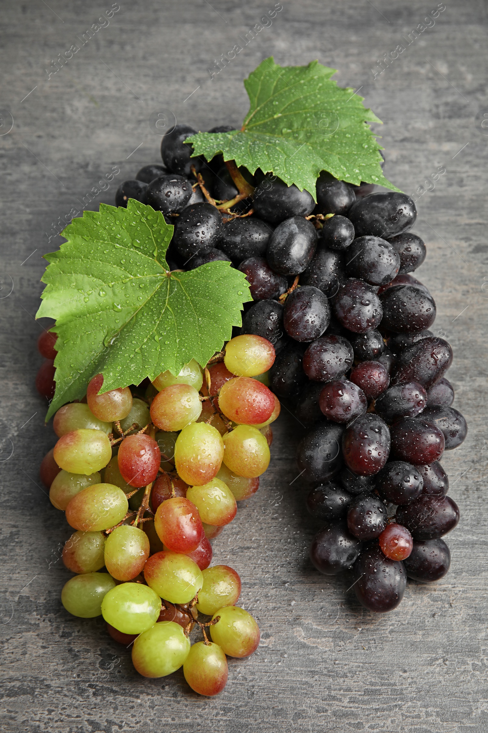 Photo of Different fresh ripe juicy grapes on table