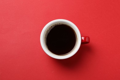 Photo of Aromatic coffee in cup on red background, top view