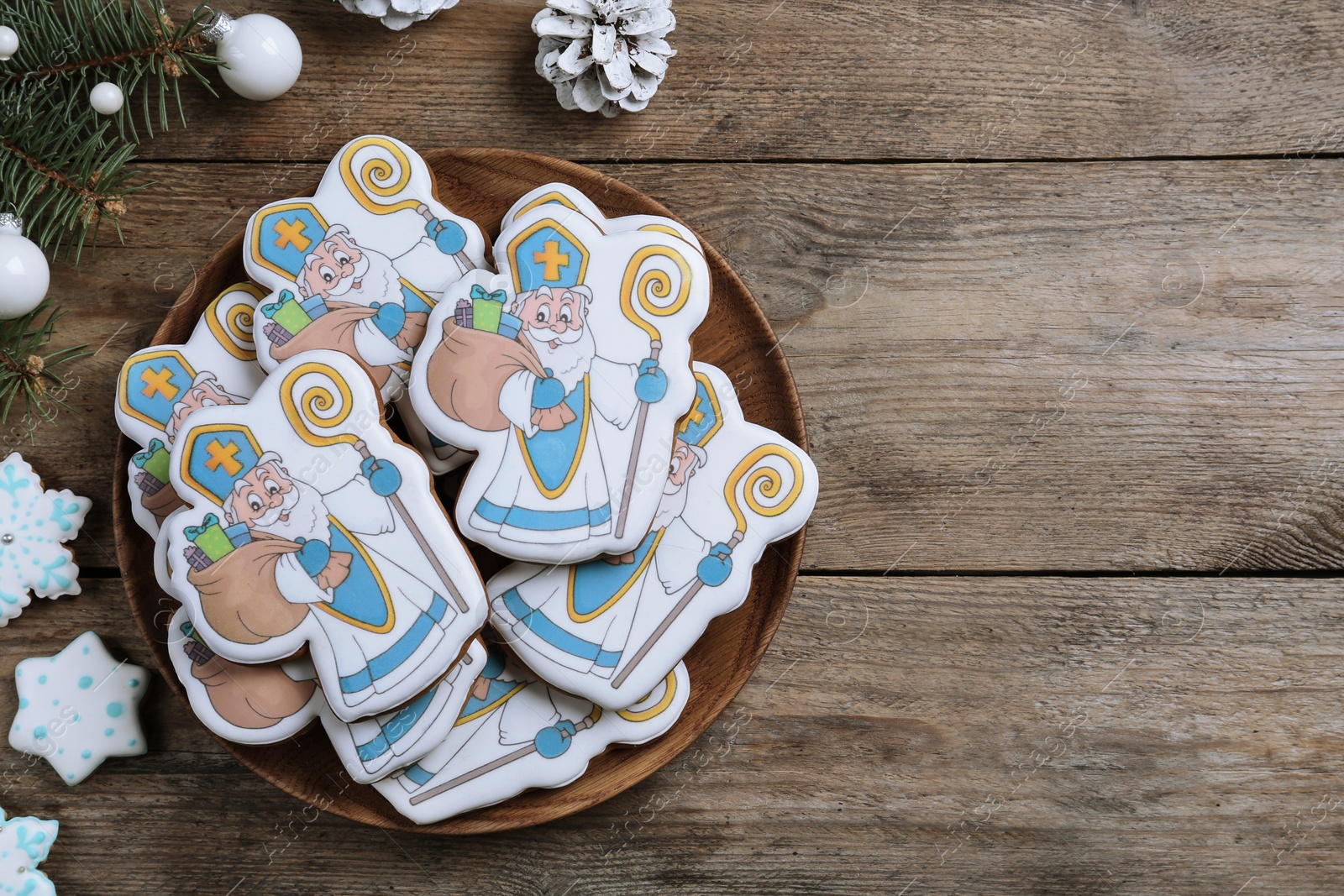 Photo of Delicious gingerbread cookies on wooden table, flat lay with space for text. St. Nicholas Day celebration