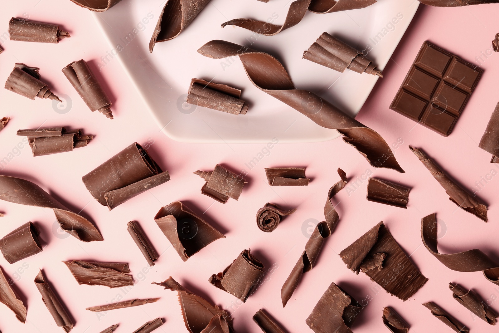 Photo of Flat lay composition with chocolate curls on color background