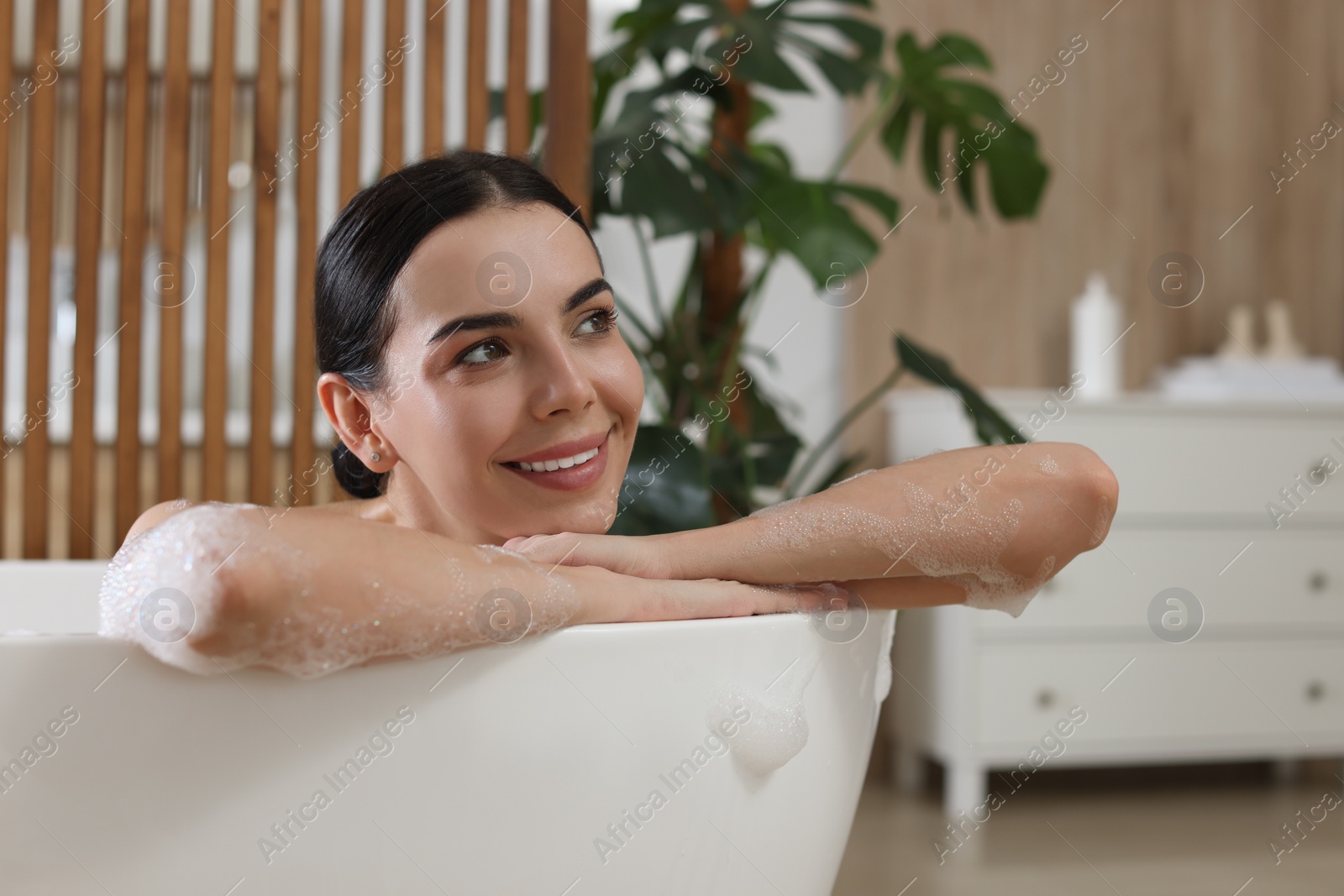 Photo of Beautiful young woman taking bubble bath at home