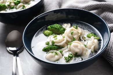 Photo of Bowl of tasty dumplings in broth served on table