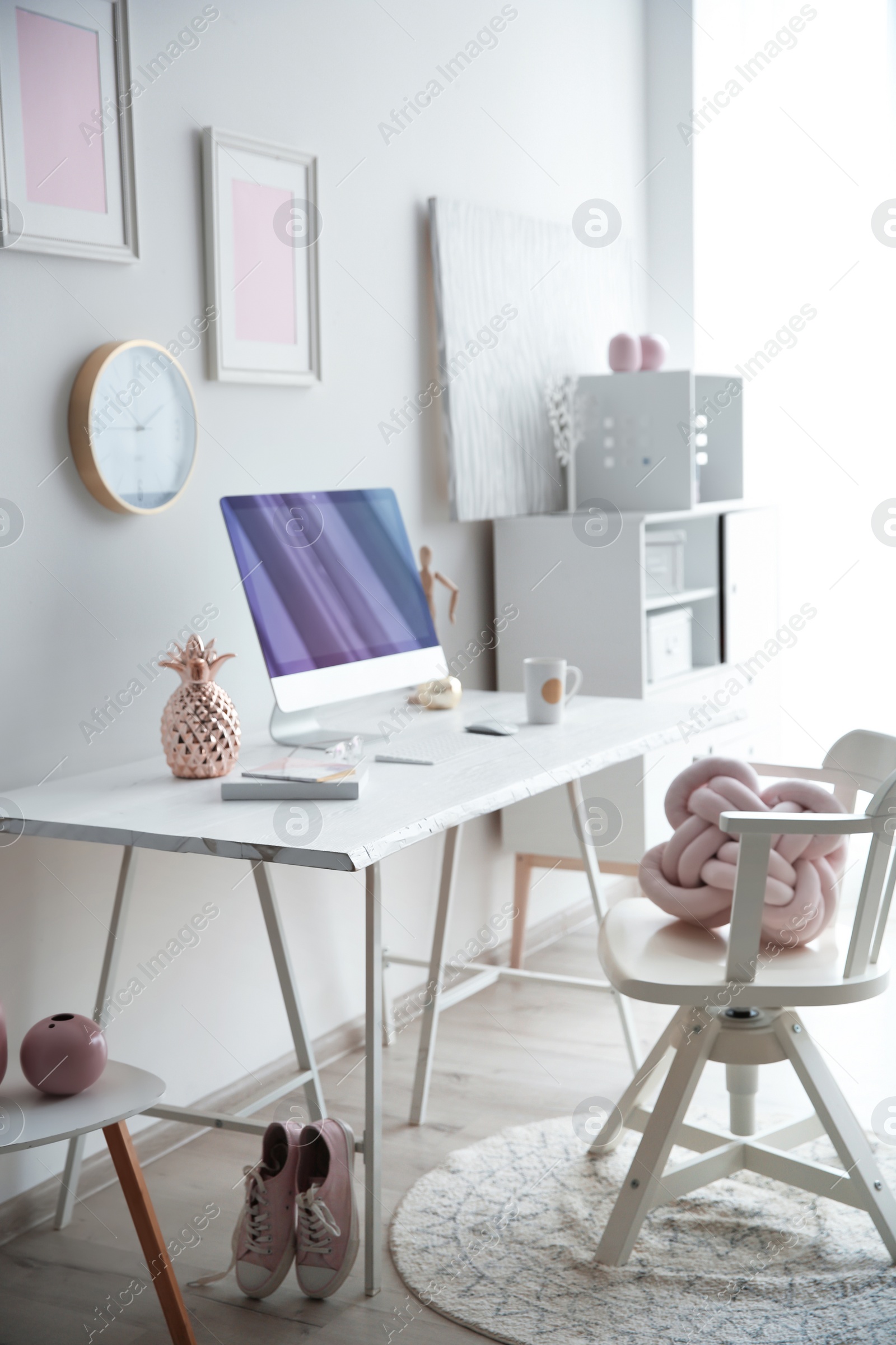 Photo of Contemporary workplace with computer on table near white wall. Interior design