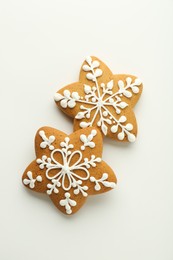 Tasty Christmas cookies with icing on white background, flat lay