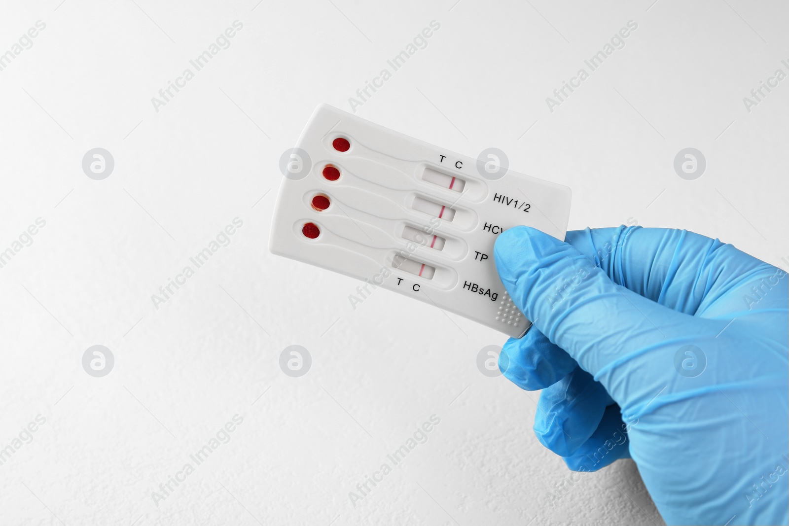 Photo of Doctor holding disposable multi-infection express test at white table, closeup