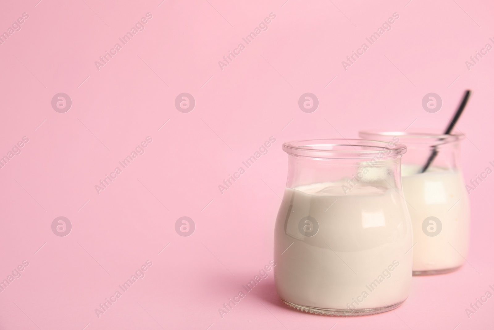 Photo of Tasty organic yogurt on pink background. Space for text