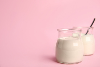 Tasty organic yogurt on pink background. Space for text