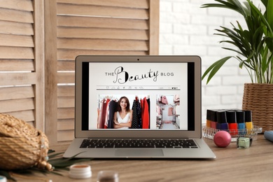 Photo of Laptop with open beauty blogger site on table