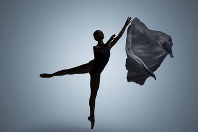 Image of Beautiful ballerina with veil dancing on light grey background. Dark silhouette of dancer