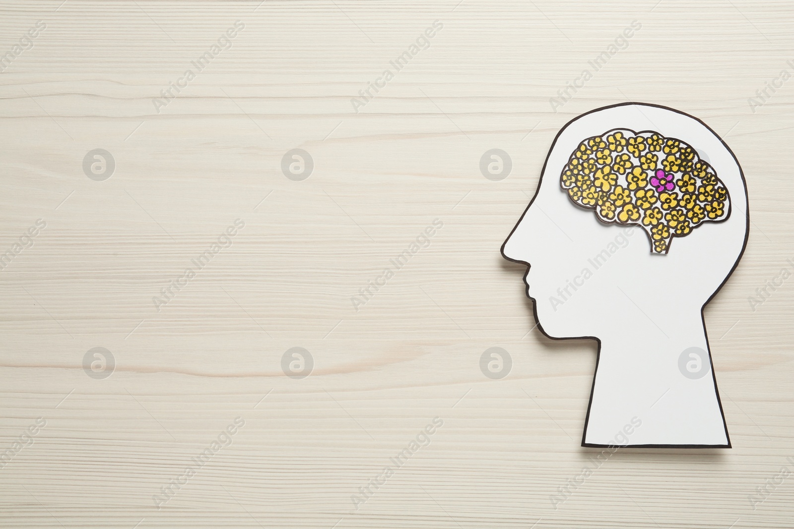 Photo of Top view of human head cutout with brain on white wooden background, space for text. Epilepsy awareness