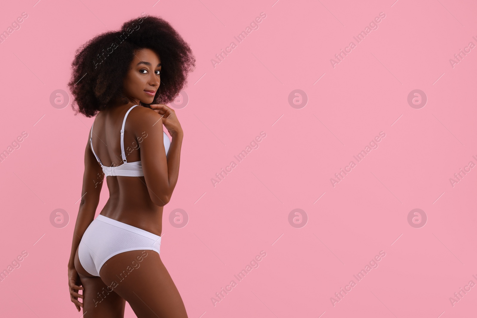 Photo of Beautiful woman in stylish bikini on pink background, space for text