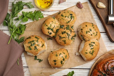 Photo of Traditional Ukrainian bread (Pampushky) with garlic on white wooden table, flat lay