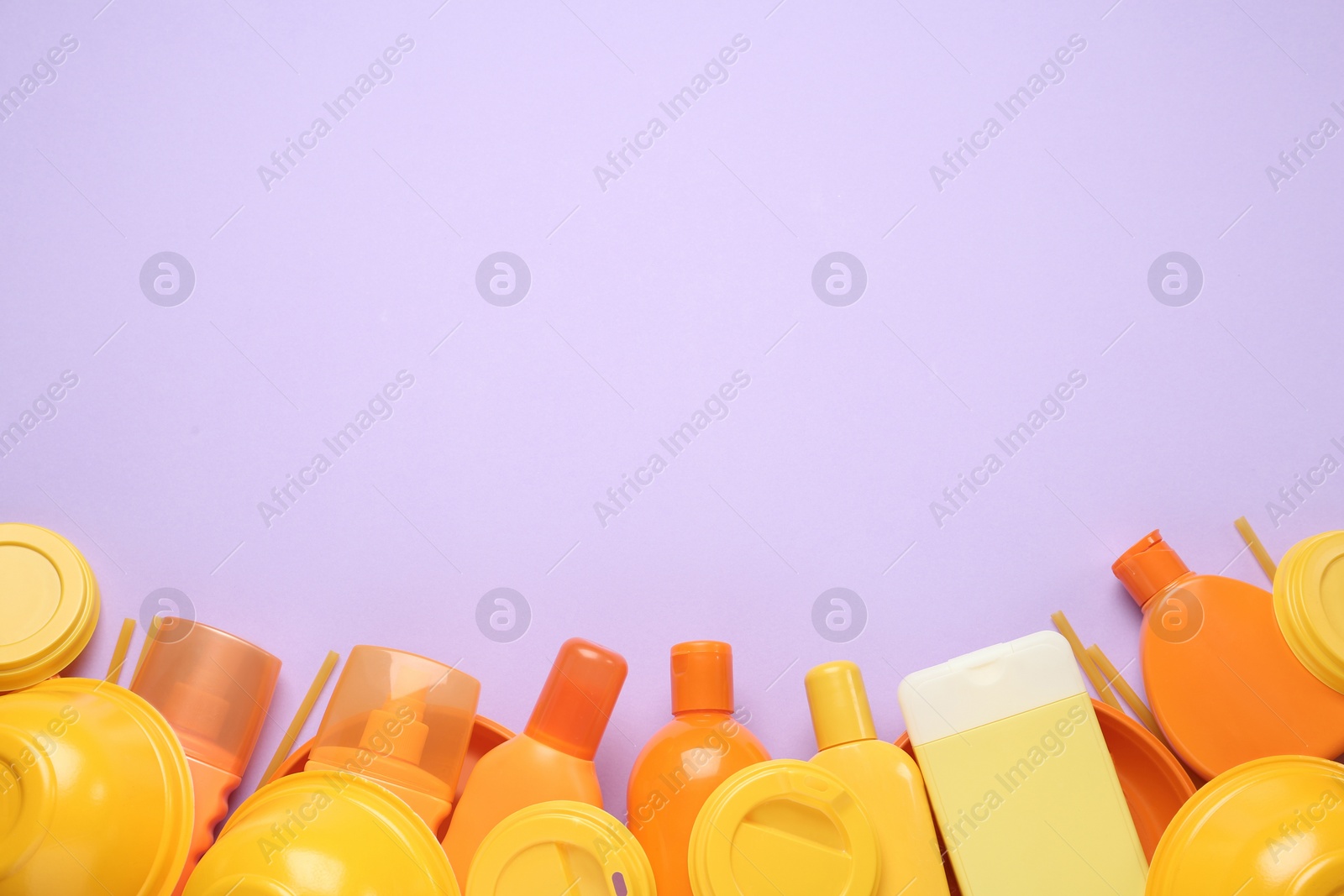 Photo of Different plastic items on lilac background, flat lay. Space for text