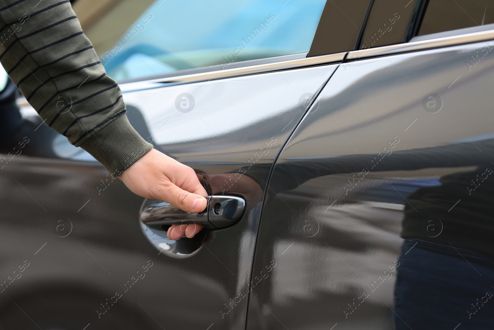 Photo of Closeup view of man opening car door