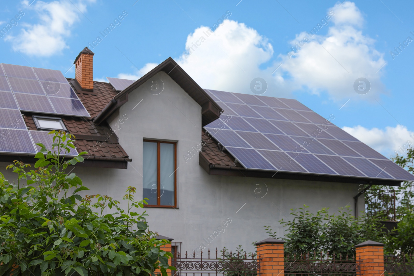 Photo of House with installed solar panels on roof. Alternative energy source