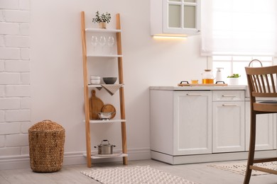 Photo of Stylish kitchen room interior with wooden ladder near white wall