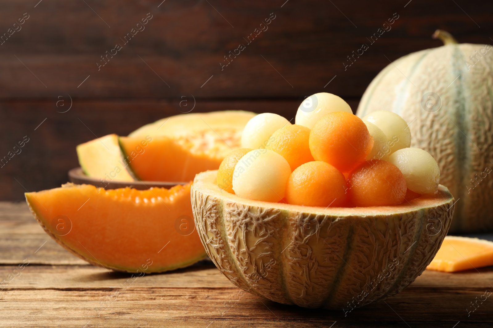 Photo of Different melon balls on wooden table. Space for text