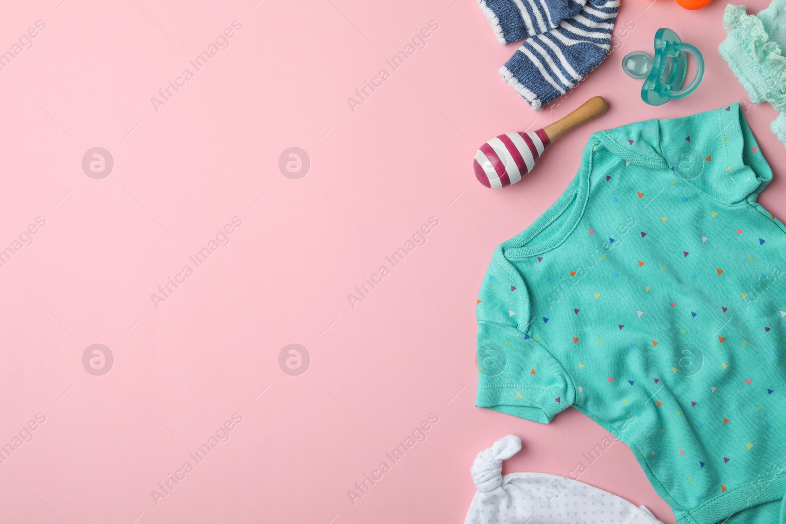 Photo of Flat lay composition with child's clothes and accessories on pink background, space for text
