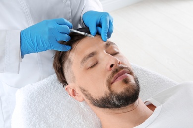 Photo of Man getting facial injection in clinic. Cosmetic surgery concept