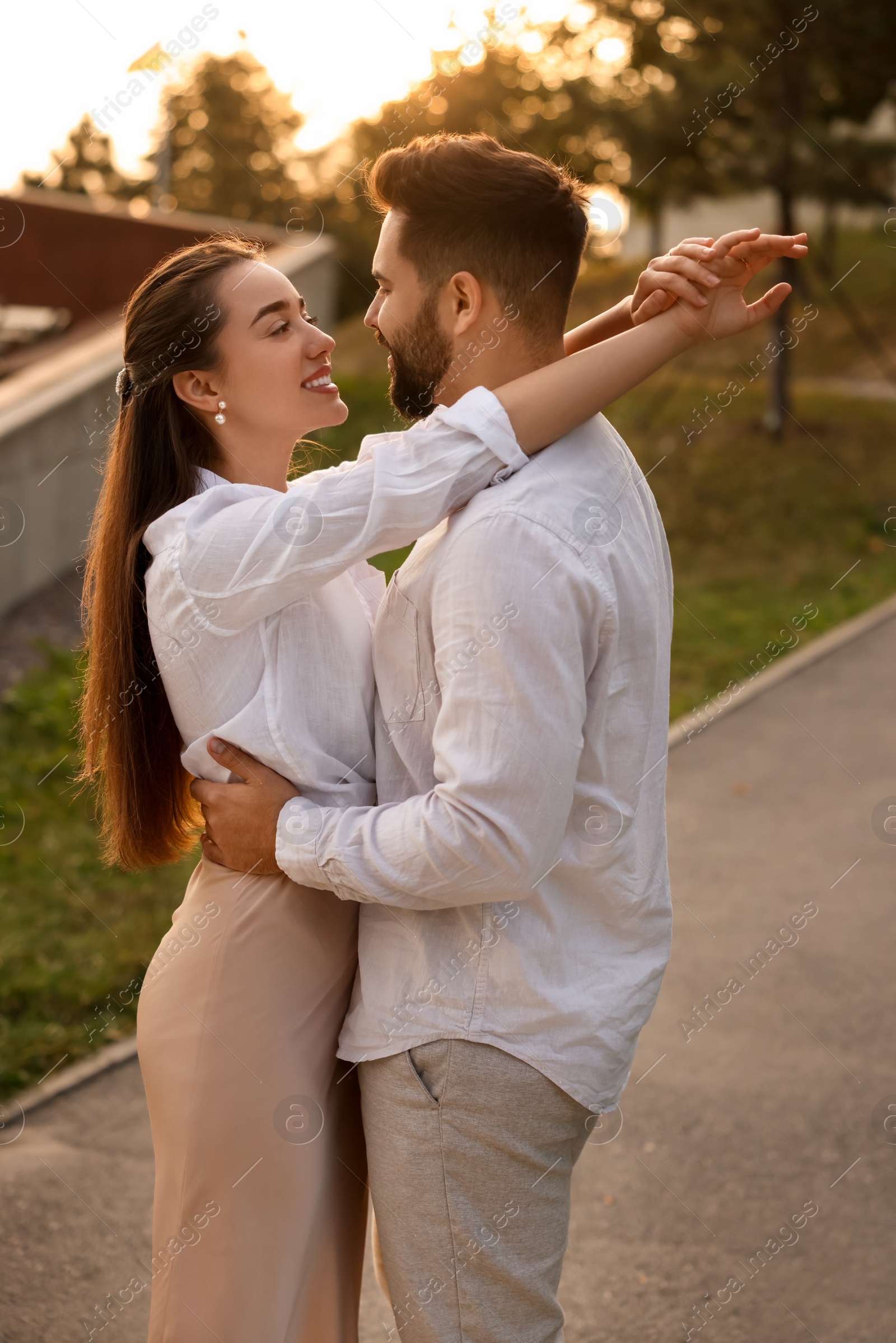 Photo of Lovely couple dancing together outdoors at sunset