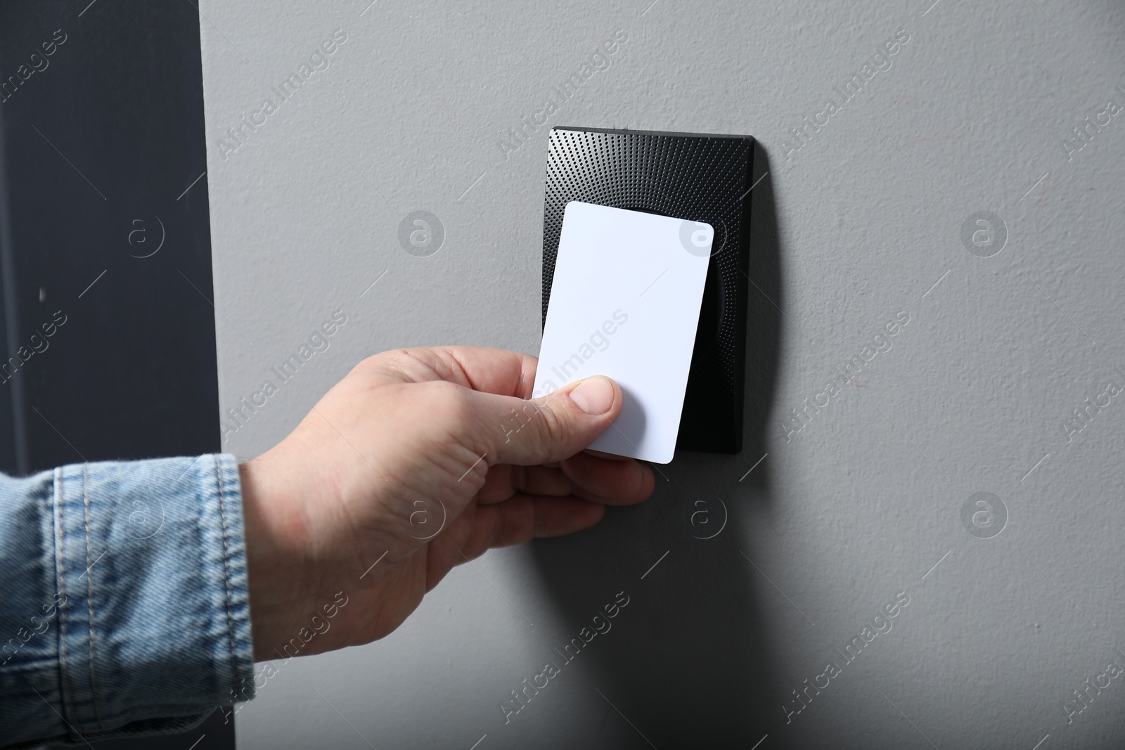 Photo of Man opening magnetic door lock with key card, closeup. Home security