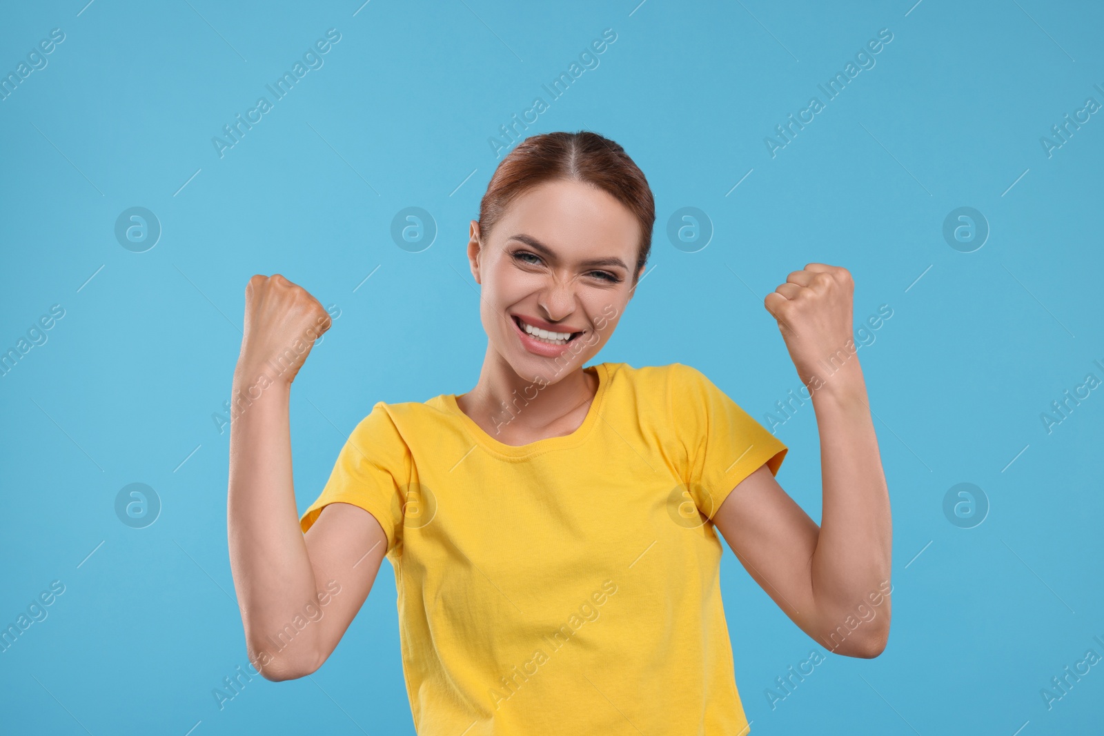 Photo of Happy fan celebrating on light blue background