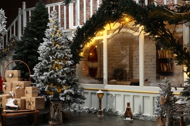 Photo of Beautiful Christmas trees, gift boxes, skates and festive decor indoors. Interior design