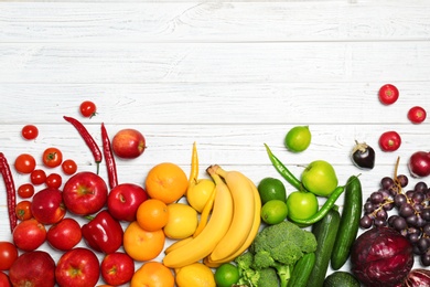 Photo of Rainbow composition with fresh vegetables and fruits on wooden background, flat lay